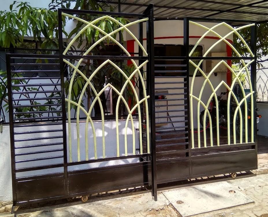 Ornate black MS swing gate with decorative elements for a residence.